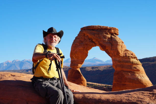 A senior hiker enjoying the views from the Delicate Arch stock photo