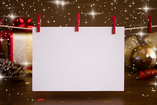 A wooden table decorated with Christmas gifts and a blank Christmas Card/ Party Invitation, with space for copy.