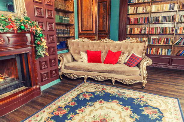 istock Classic Christmas New Year decorated interior room home library with fireplace. Christmas tree with red ornament decorations. Modern classical style interior design apartment. Christmas eve at home 1190450098