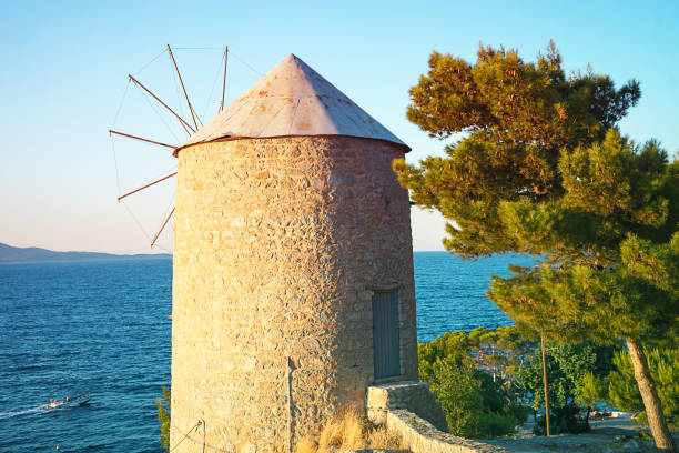 Beautiful view on old wind mill and sea on island Hydra, Greece on sunset time. The best travel destination in Europe. Selec tive focus.