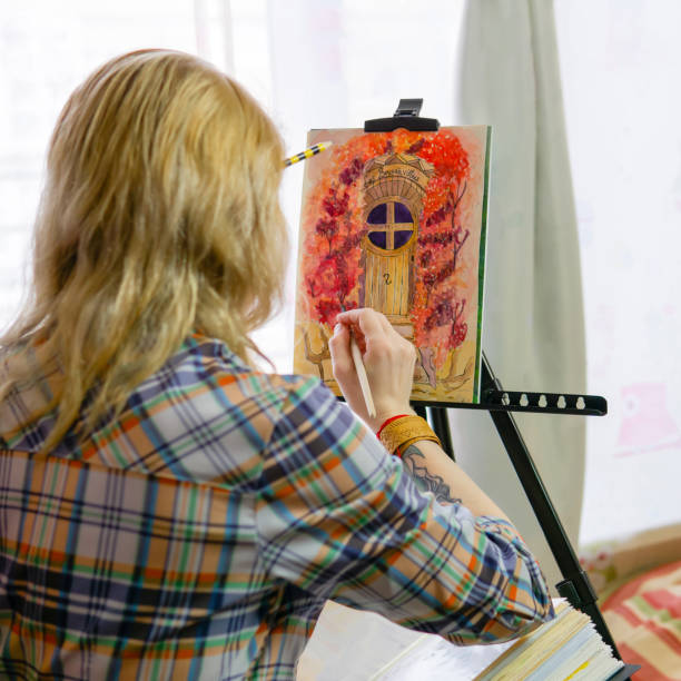 女性イラストレーターが画像を完成 - women artist painting easel ストックフォトと画像