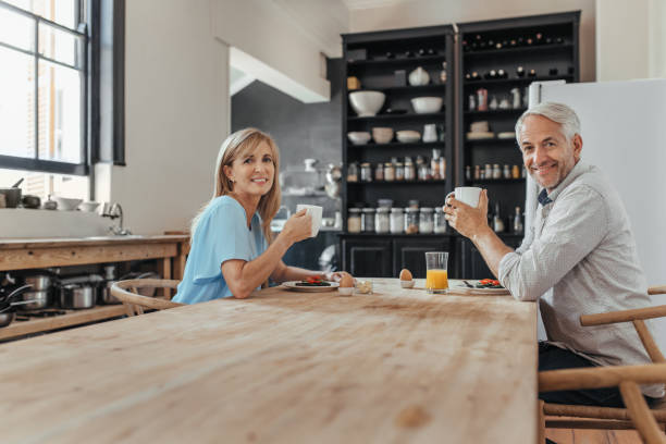 istock Smiling mature couple enjoying breakfast together in their kitchen 1190451666