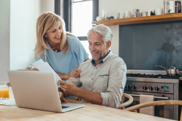 istock Mature couple smiling while doing their online banking together 1190452244