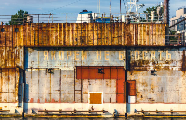 istock Rusty equipment in river docks with Russian lettering - No anchoring 1190453024