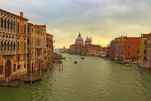Breathtaking landscape of Grand Canal with turquoise water.It's the main water-traffic corridor in the city. Buildings and palazzo along the canal. Basilica Santa Maria della Salute in the background.