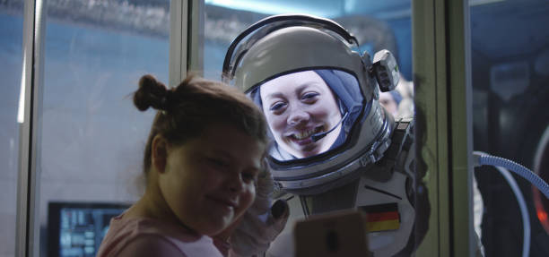 出発前に手のひらを女の子とマッチングする宇宙飛行士 - three person family flash ストックフォトと画像