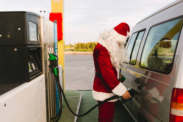 Santa Claus fueling up in his car in a petrol station stock photo
