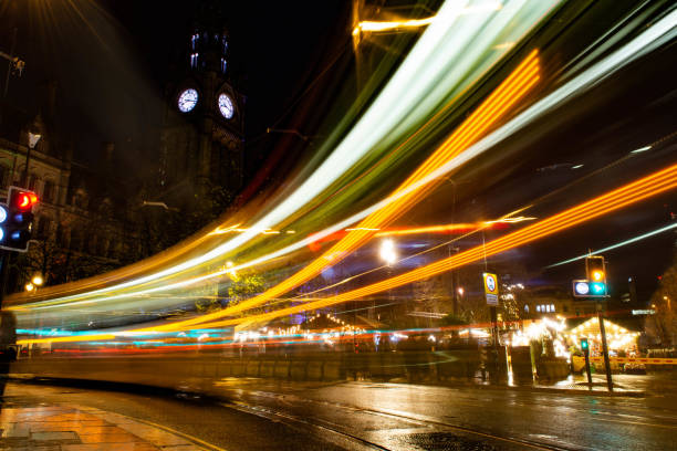 istock Light drag caused by a passing Manchester tram within albert square during the Christmas markets at night. In the background the clock tower of the town hall can be seen. 1190459879