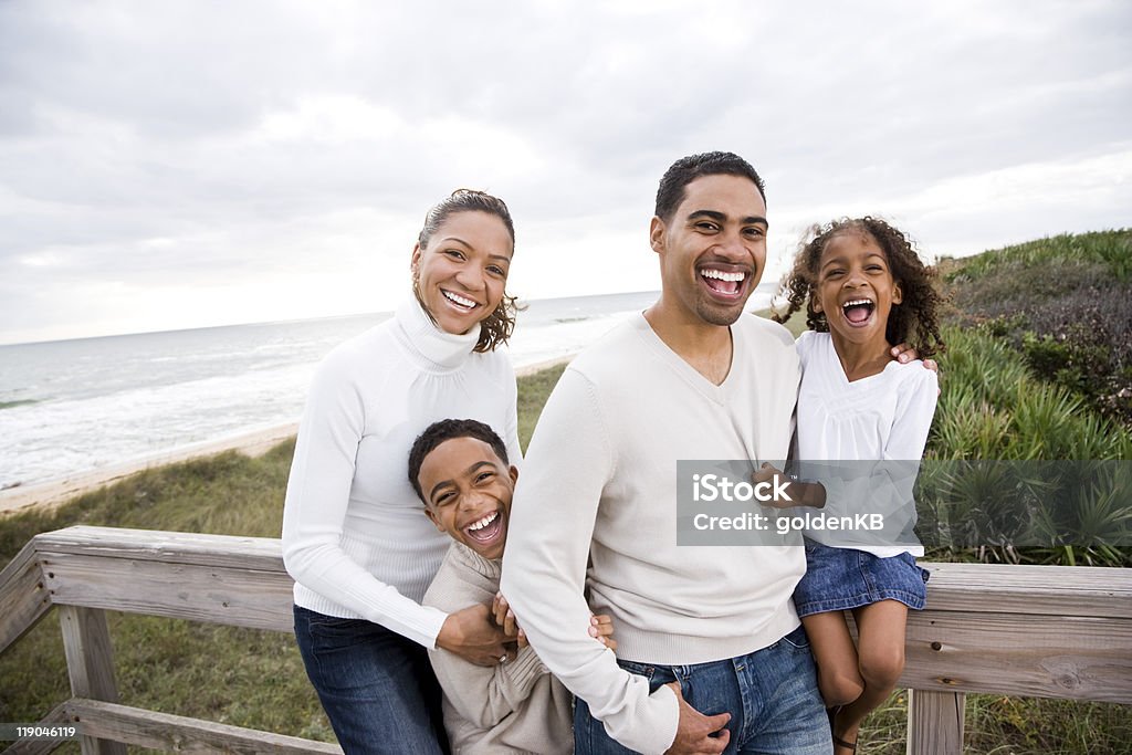 Happy African-American family of four on beach  Happiness Stock Photo