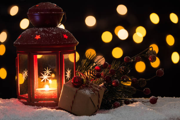 istock Christmas lantern with a wrapped gift and pine branch on snow 1190462717