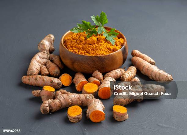 Turmeric Powder In A Wooden Bowl And Fresh Turmeric Stock Photo - Download Image Now