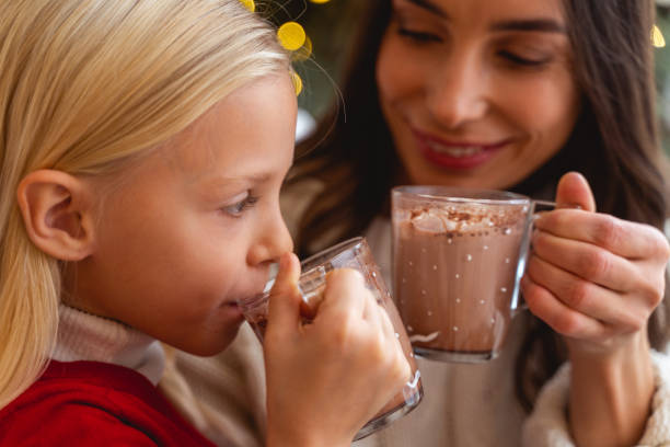 Close up portrait of a little girl drinking hot cocoa