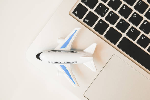 istock Model airplane stands on a laptop. Online Flight Schedule Review Concept. Top view. 1190466025