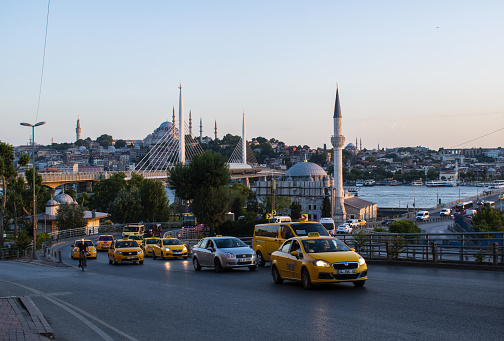 Istanbul, Turkey, Middle East - June 24, 2019: daily life, a row of taxis in city traffic with view on the Golden Horn and Suleymaniye mosque, Ottoman imperial mosque ordered by Suleiman the Magnificent