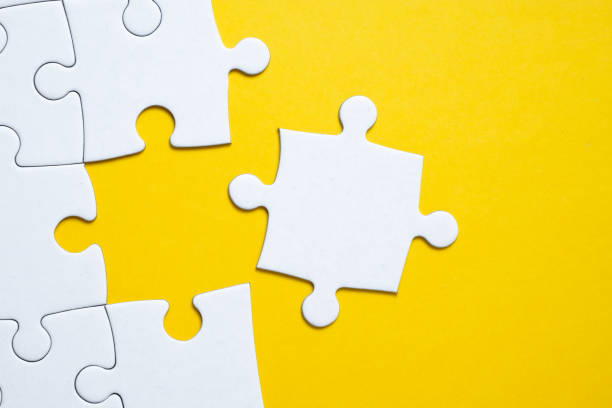 istock Final white piece is lying next to the jigsaw puzzle on yellow background. 1190466169