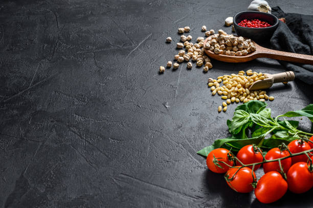 istock Hummus ingredients, garlic, chickpeas, pine nuts, Basil, pepper. Black background. Top view. Space for text 1190466260