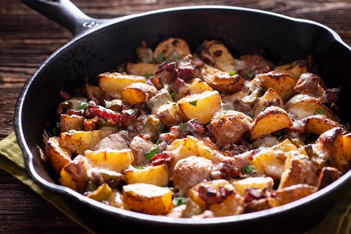 Roasted Potatoes with Bacon (or Pancetta) and Melted Cheese in a Cast Iron Skillet.