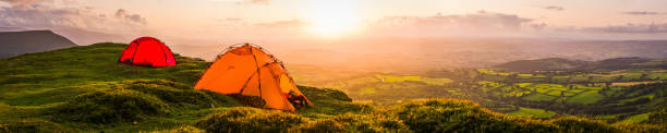 istock Tents wild camping on mountain overlooking idyllic valley sunset panorama 1190466576