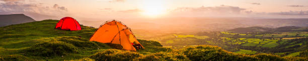 tents wild camping on mountain overlooking idyllic valley sunset panorama - wales mountain mountain range hill imagens e fotografias de stock