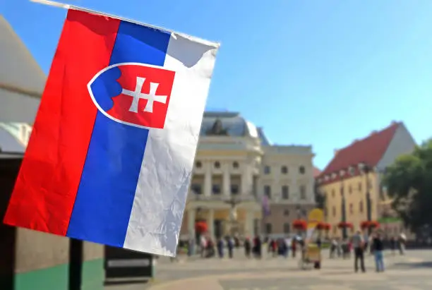 Photo of National flag of Slovakia and view of Slovak National Theatre on Hviezdoslavovo square. The Neo-Renaissance building was built in 1885 1886