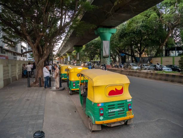 reihe von rikscha-taxis am straßenrand wartet auf passagiere - india bangalore contemporary skyline stock-fotos und bilder