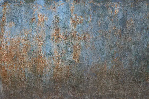 Photo of Old metal sheet with cracked blue paint. There is rust. Background. Texture.