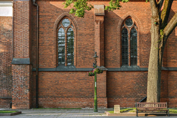 Two arched Windows with stained glass on the brick wall of the Cathedral of saints Peter and Paul in the old part of Kaunas. From the Windows of the world series.
