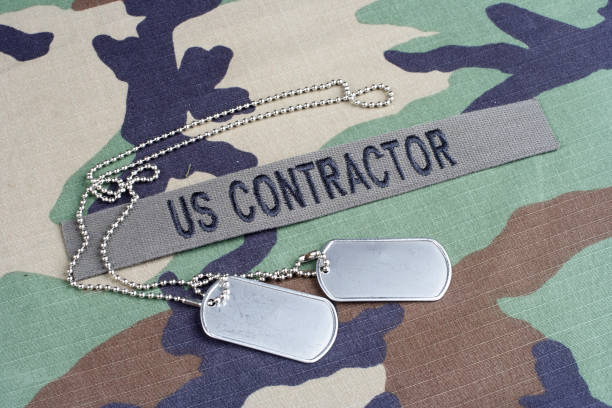 US CONTRACTOR branch tape and dog tags on woodland camouflage uniform US CONTRACTOR branch tape and dog tags on woodland camouflage uniform woodland camo stock pictures, royalty-free photos & images