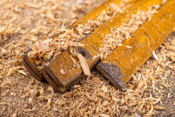 istock Carpentry measure in sawdust on a wooden table. Small carpentry work in a home workshop. Dark background. 1190482321