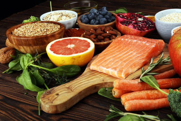 istock Healthy food clean eating selection: fish, fruit, vegetable, cereal, leaf vegetable on rustic background 1190491624
