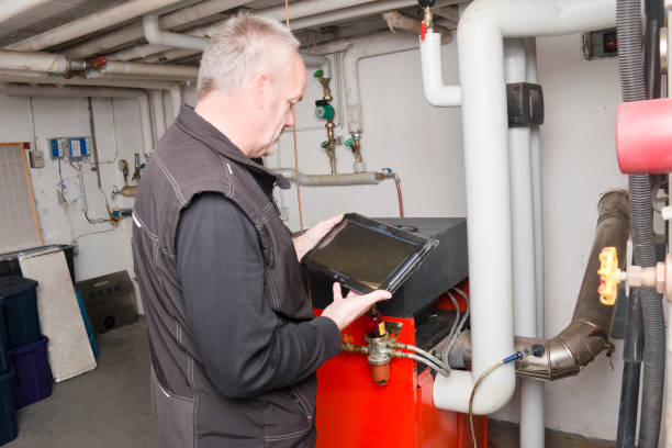 기술자가 오래된 오일 히터의 배출을 측정하기 위해 확인 - plumber water heater radiator occupation 뉴스 사진 이미지