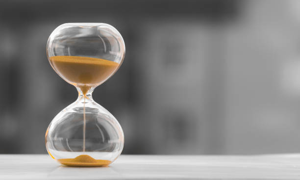 istock Hourglass on a black white blurred background. Time is money. 1190495795