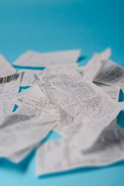 Pile of shopping receipts on blue background stock photo