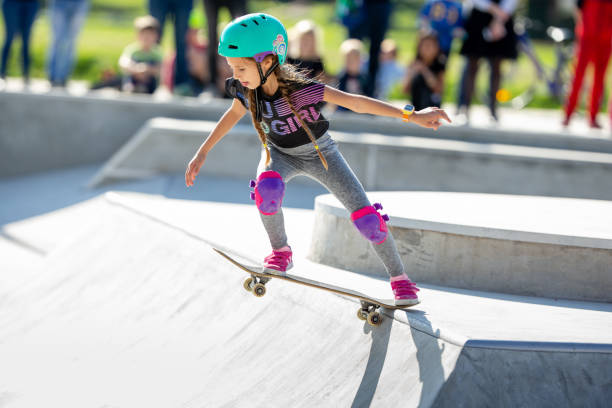 Skater Girl in the Middle of Dropping In bei Skateboarding Contest im Skate Park - Stock Photo – Foto