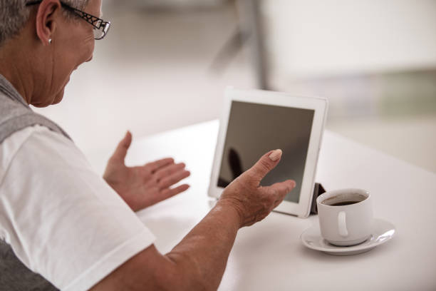 istock Senior woman gesticulating while on a video call on her digital tablet 1190505720
