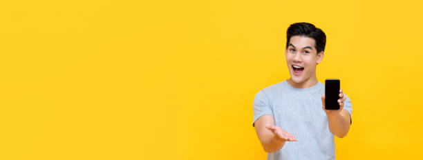 istock Wow excited young Asian man showing mobile phone with open hand 1190506488