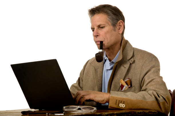 istock Man with pipe in mouth at laptop typing 1190507997