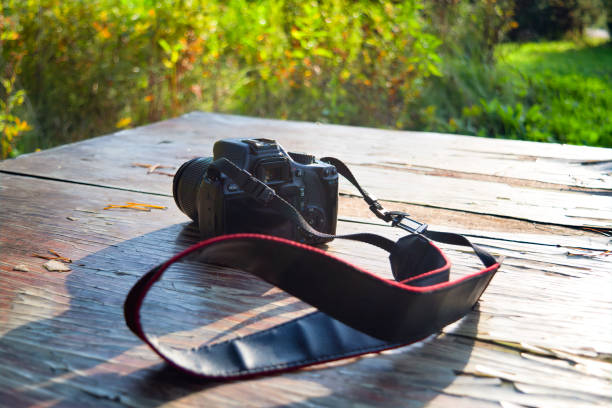 istock Camera on an old wooden table against sunlight and a blurred background.. Closeup. 1190508876