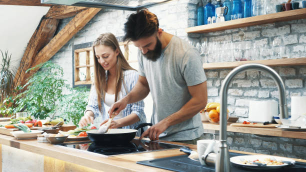 istock Young couple making dinner together at home 1190518423