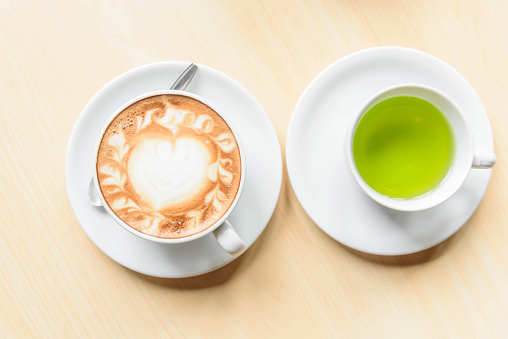 hot cappuccino coffee with green tea on table