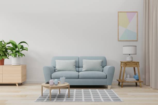 istock Mock up wall in living room with blue sofa, plants and table on empty white wall background. 1190520571