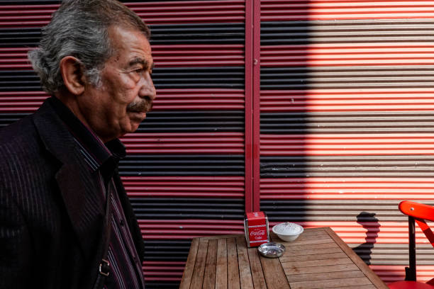 Istanbul, Turkey Nov 25, 2019 A senior man walks by a colourful wall and outdoor restaurant table.