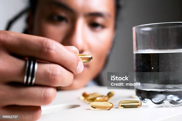 Tomar Medicina Foto de stock y más banco de imágenes de 20 a 29 años - 20 a 29 años, Aceite de pescado, Adulto