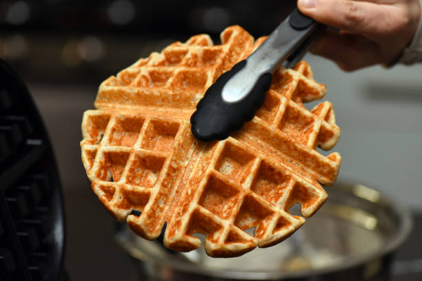 istock Whole wheat waffle in waffle iron 1190534474