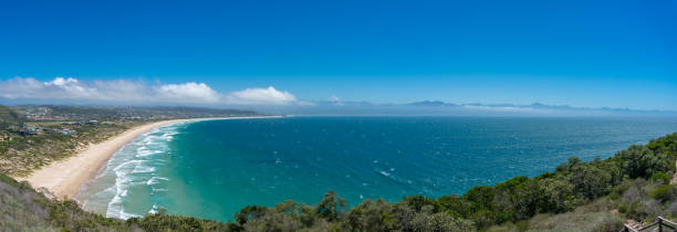 epic panorama landscape with ocean beach and seaside town. plettenberg bay, south africa - plettenberg bay tourist resort south africa coastline imagens e fotografias de stock