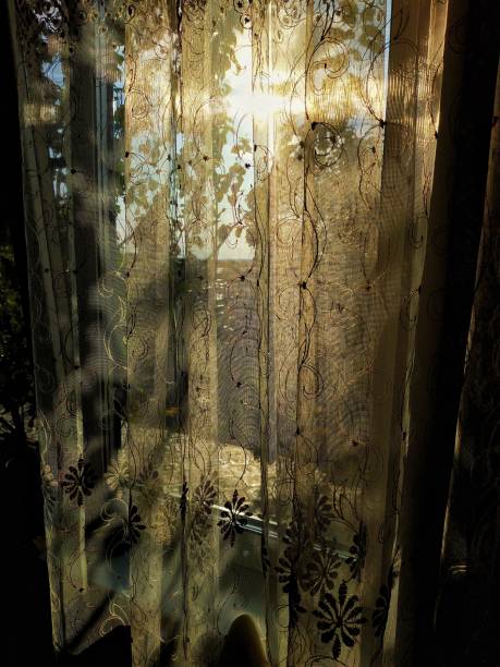 istock Sun at sunset light through the thin curtains on the window 1190541168