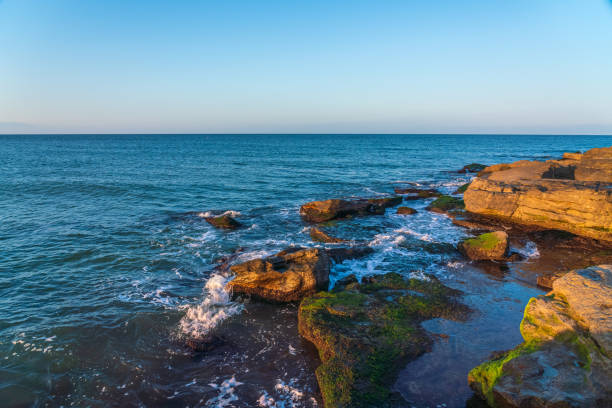 Splashing waves on the coastal cliffs at sunset