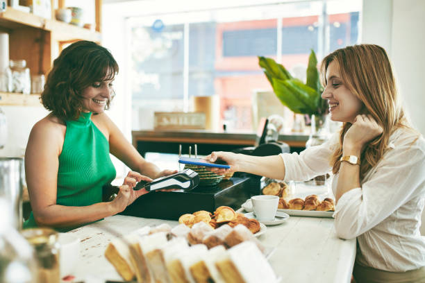 istock Smiling Cafe Proprietor and Patron Using Mobile Payment 1190547789