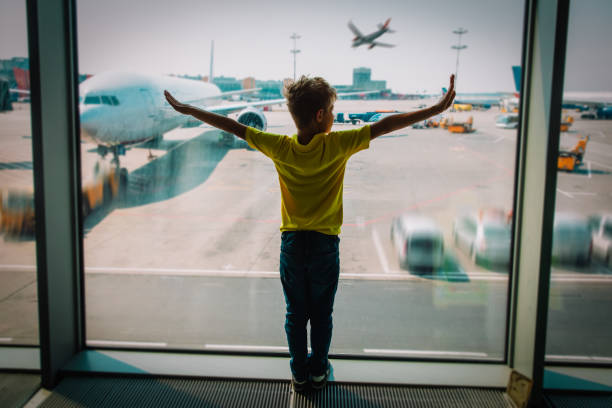 istock young boy looking at planes in the airport 1190548039