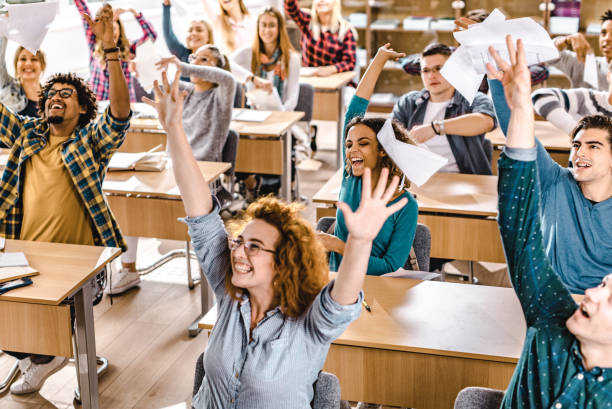 istock Large group of cheerful students having fun while celebrating the end of a class in the classroom. 1190548698